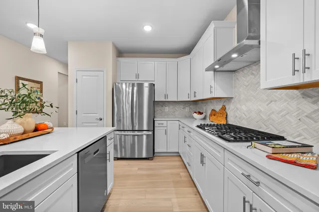 a kitchen with stainless steel appliances granite countertop a refrigerator a stove and a sink