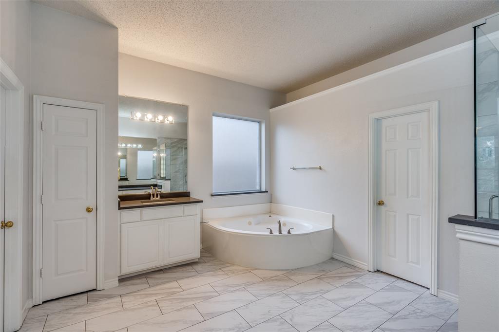 3421 Neiman Road Plano, TX 75025 - Photo 19 of 40 Bathroom featuring marble finish floors, vanity, a bath, and a textured ceiling