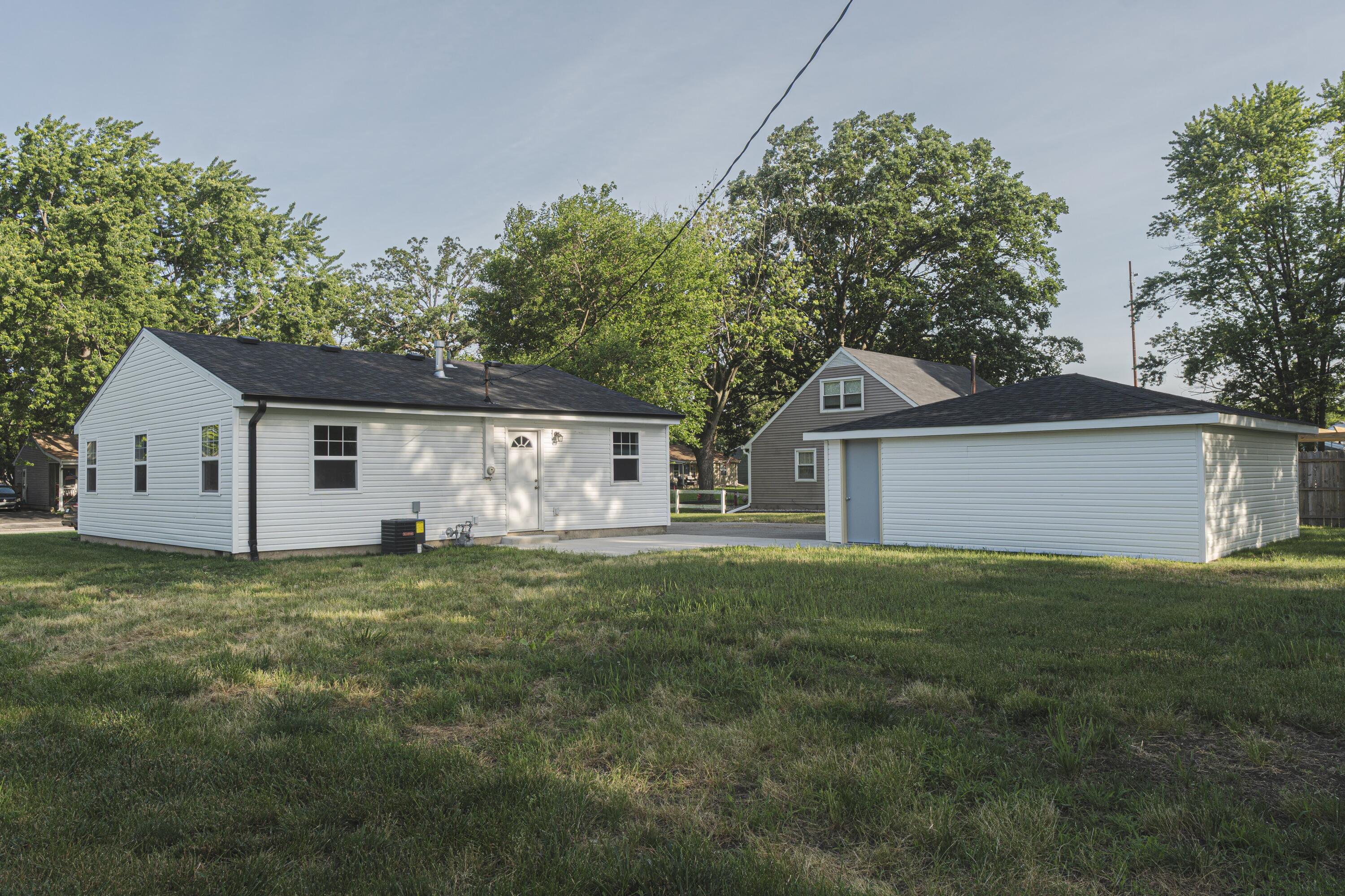 719 Imperial Road Valparaiso, IN 46385 - Photo 10 of 12 a house that is sitting in the grass with large trees and plants