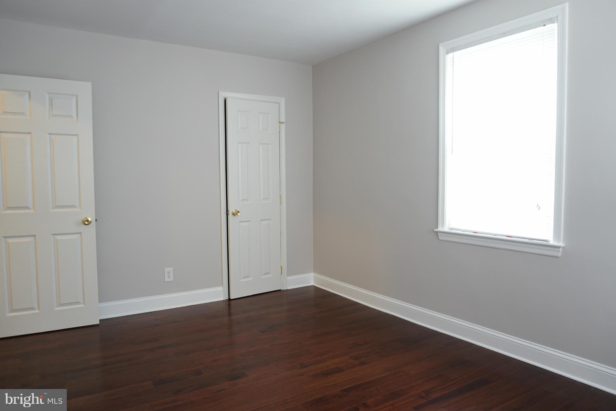 901 Wicklow Road Baltimore, MD 21229 - Photo 24 of 29 an empty room with wooden floor and windows