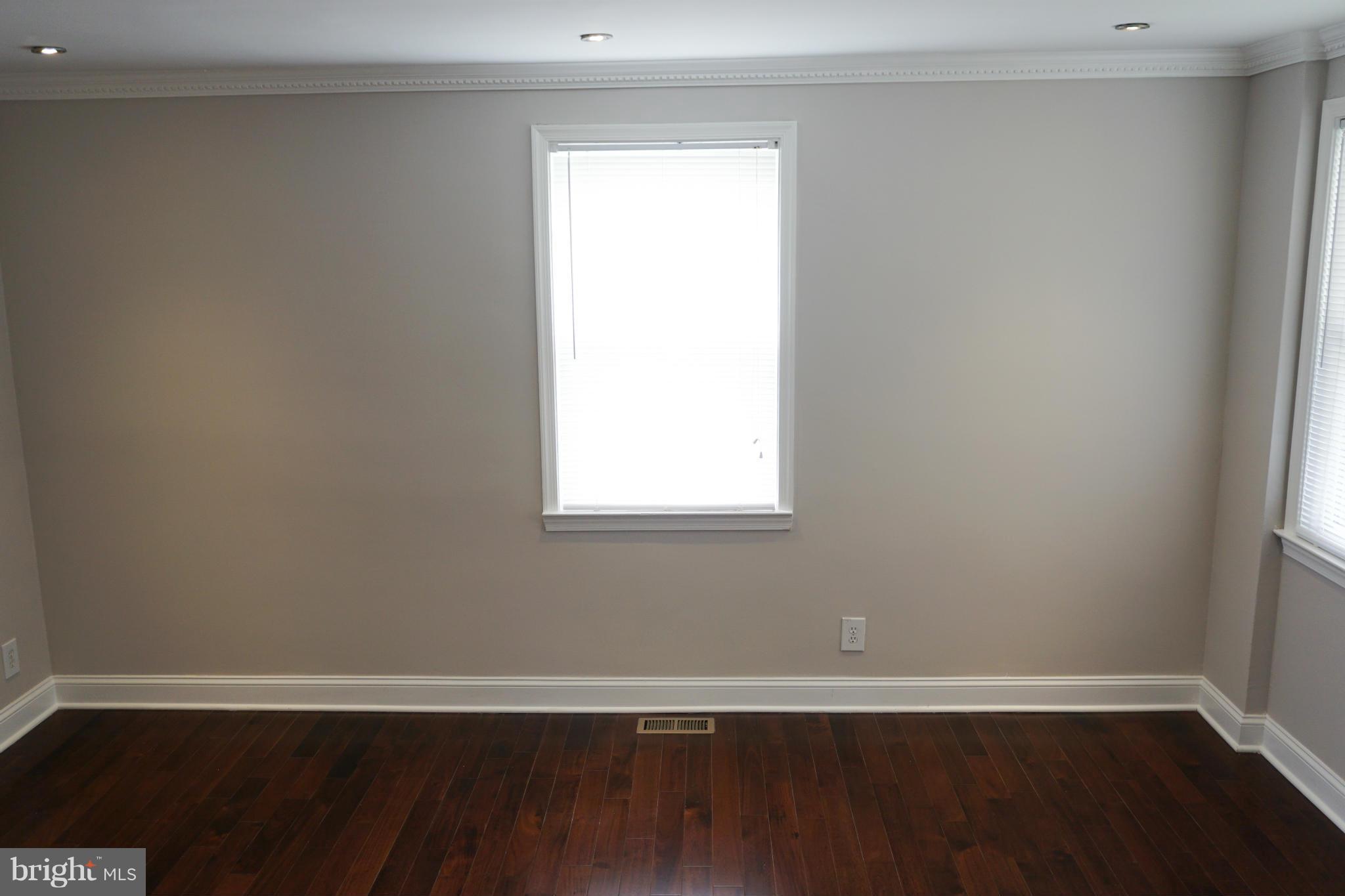 901 Wicklow Road Baltimore, MD 21229 - Photo 27 of 29 a view of an empty room with wooden floor and a window