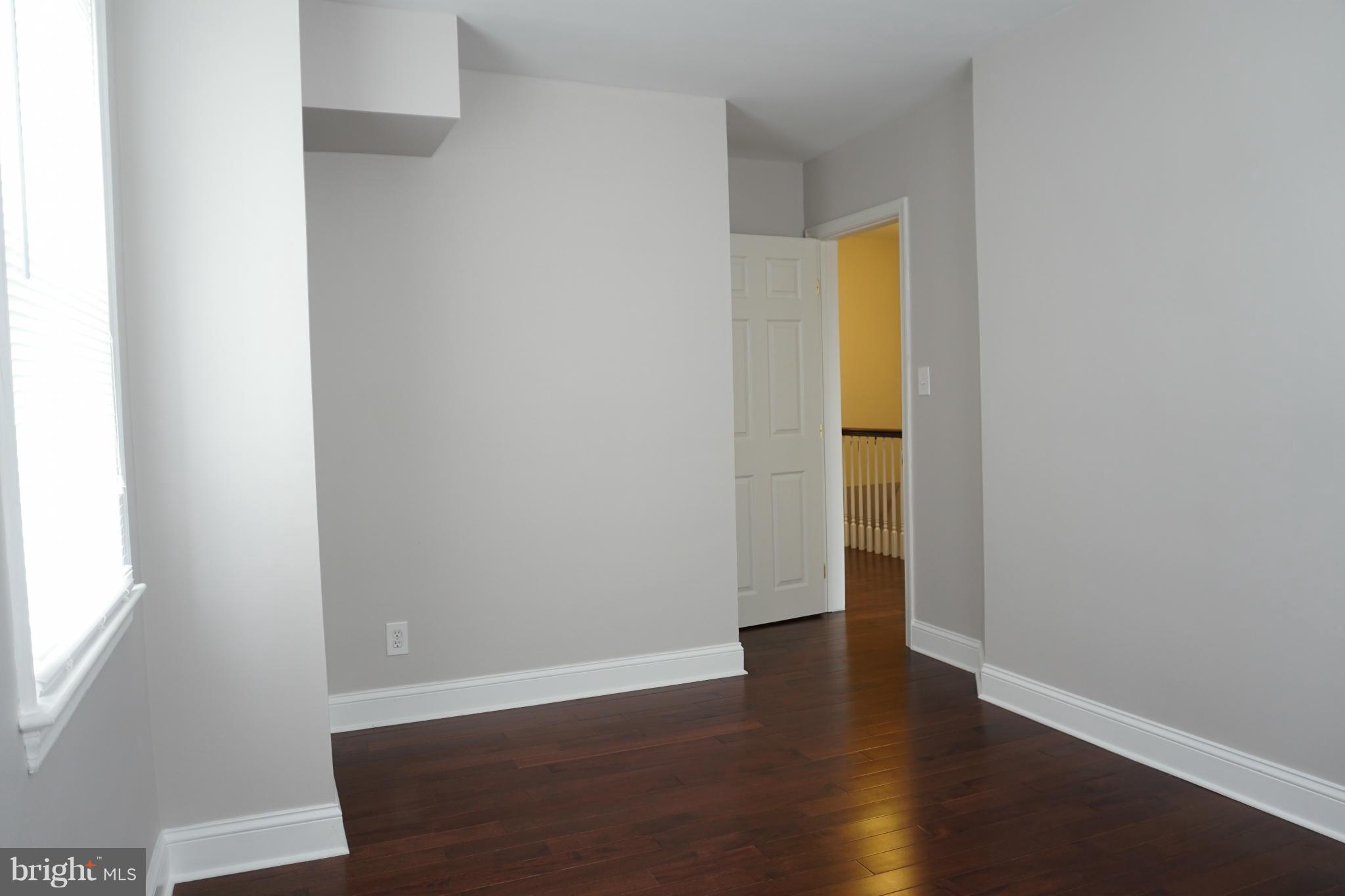 901 Wicklow Road Baltimore, MD 21229 - Photo 28 of 29 a view of an empty room with wooden floor and a window