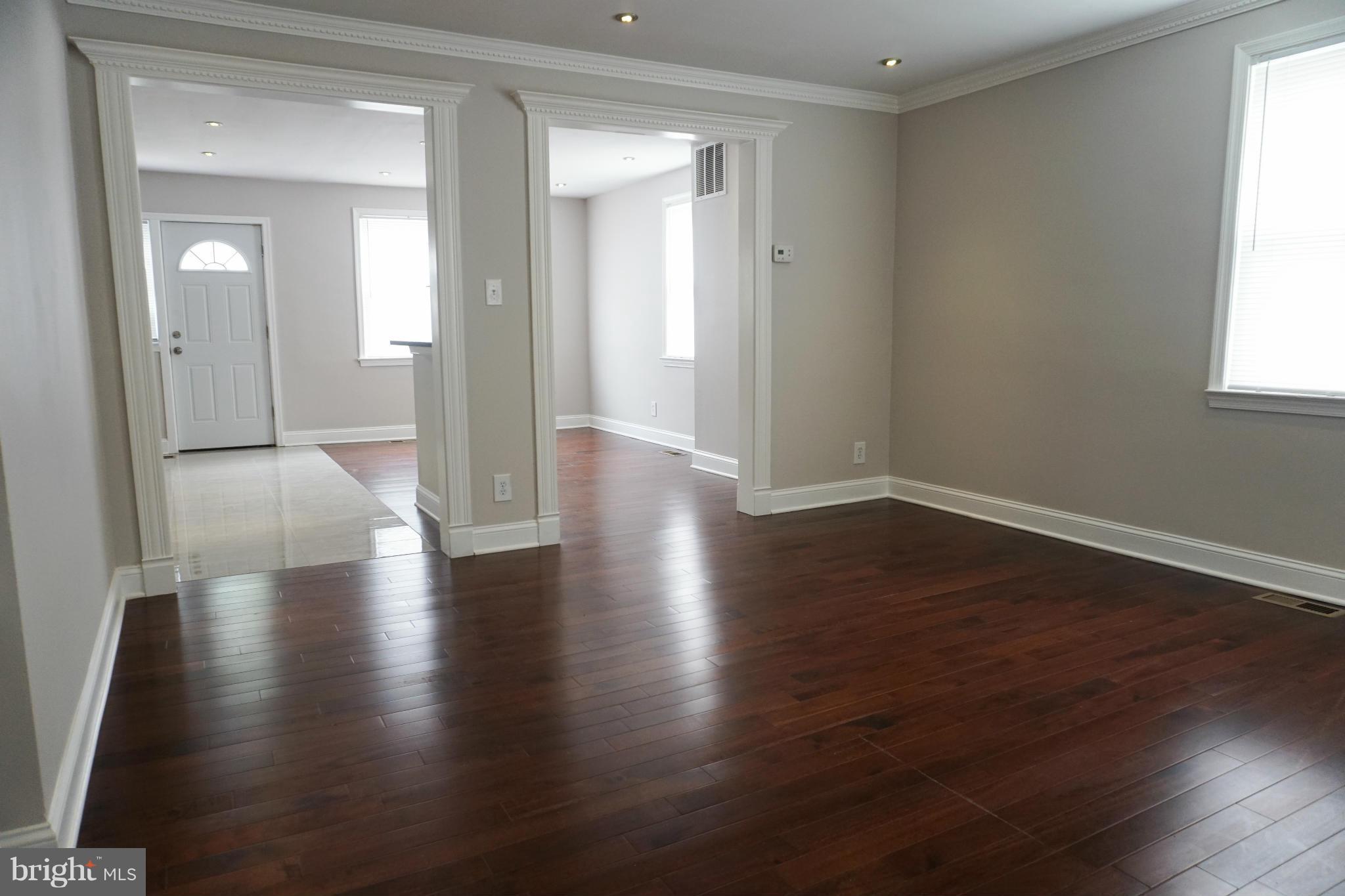 901 Wicklow Road Baltimore, MD 21229 - Photo 5 of 29 an empty room with wooden floor and a window