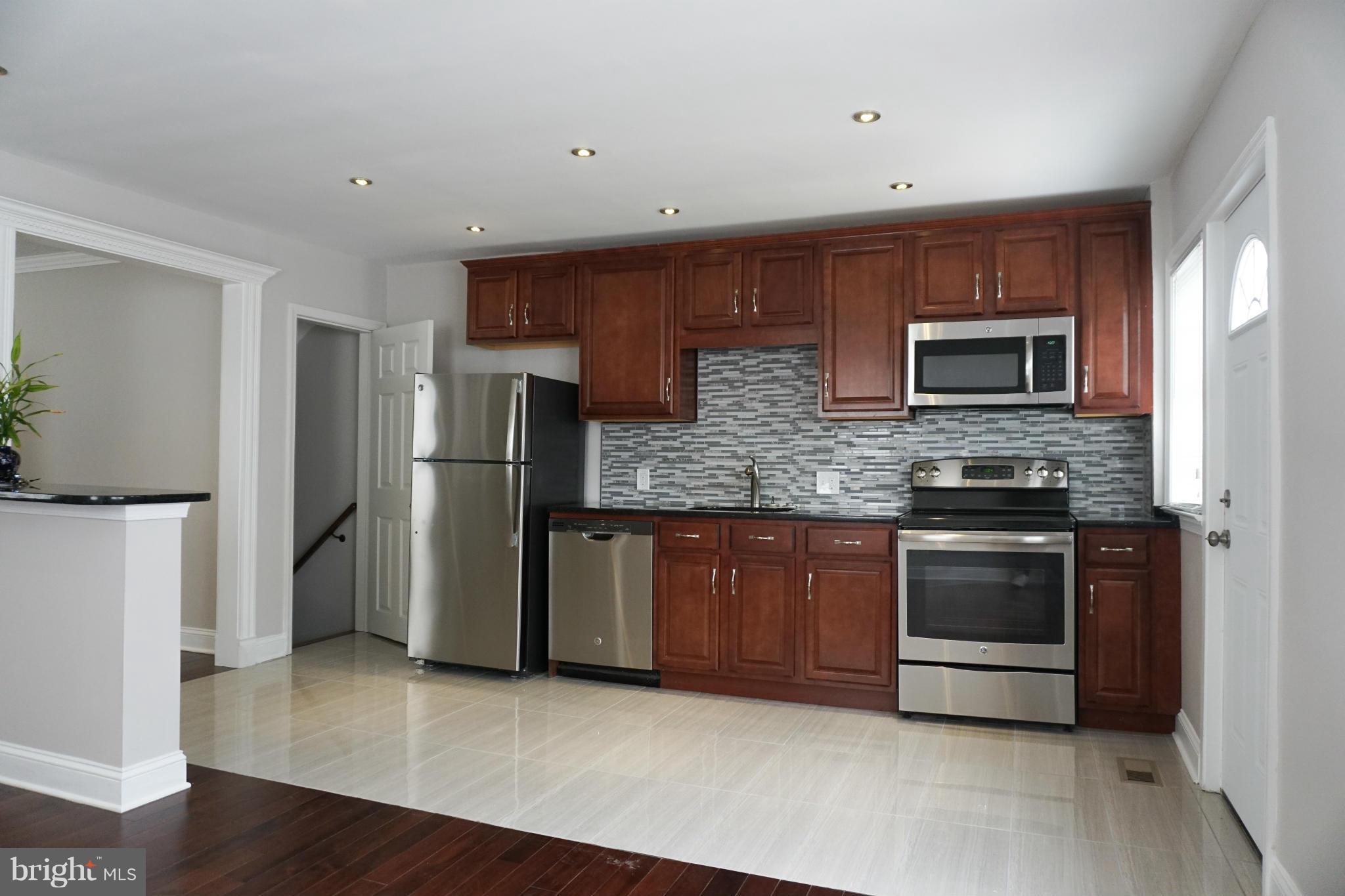 901 Wicklow Road Baltimore, MD 21229 - Photo 7 of 29 a kitchen with stainless steel appliances granite countertop a refrigerator and a stove top oven