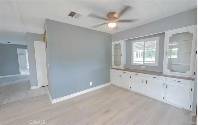 a view of a kitchen with wooden floor electronic appliances and windows