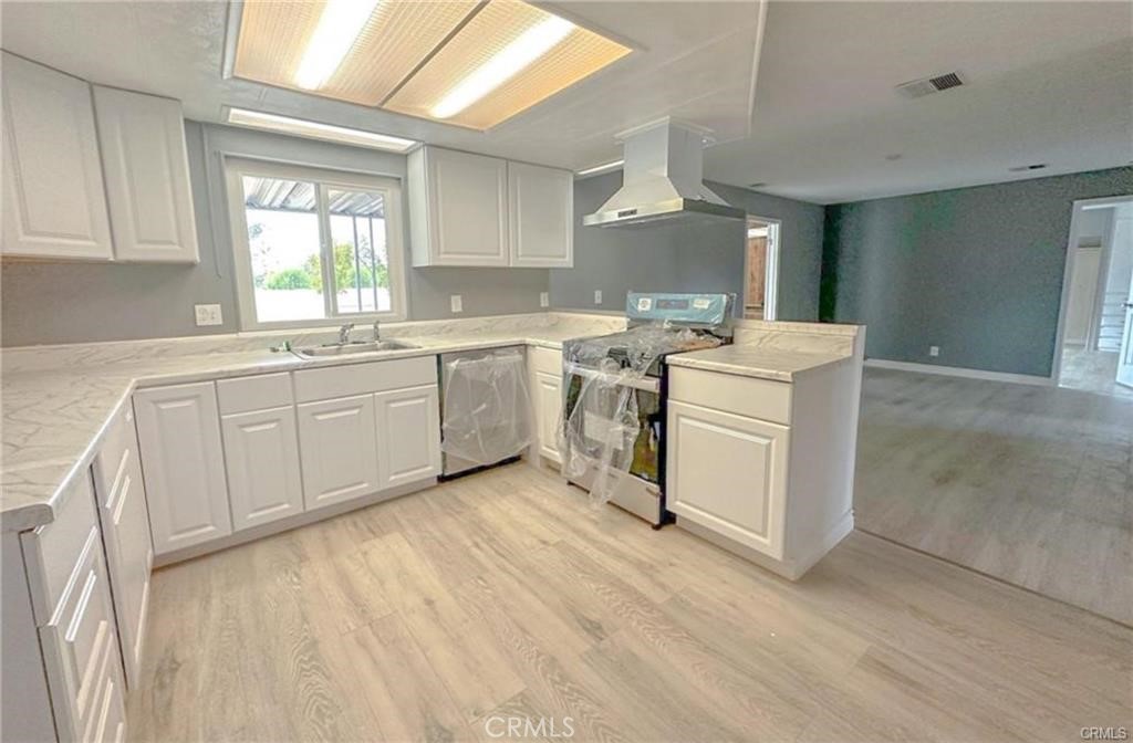 28160 Patterson Avenue Winchester, CA 92596 - Photo 18 of 57 a kitchen with a stove a sink and white cabinets