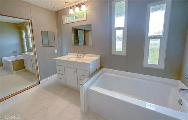 a bathroom with a tub sink and mirror