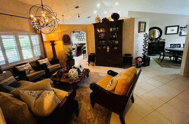 a living room with furniture a chandelier and a window