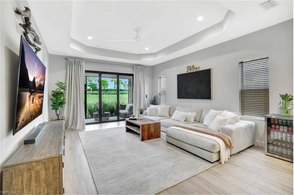 4621 Centaurus Circle Naples, FL 34120 - Photo 11 of 47 Living area with a ceiling fan, light wood-style tile floor, recessed lighting, and a raised ceiling staged for photo