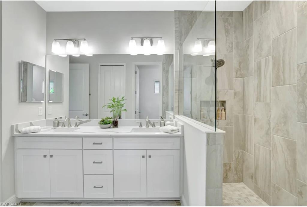 4621 Centaurus Circle Naples, FL 34120 - Photo 14 of 47 Bathroom with a walk in shower and double vanity staged for photo