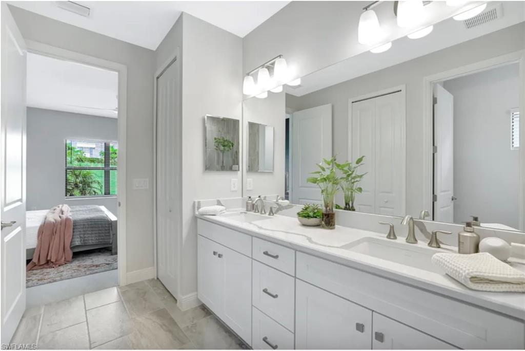 4621 Centaurus Circle Naples, FL 34120 - Photo 15 of 47 Ensuite bathroom with a closet, double vanity, and light marble finish floors staged for photo