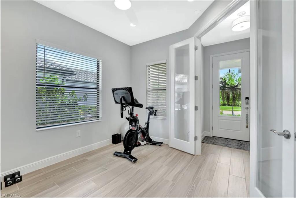 4621 Centaurus Circle Naples, FL 34120 - Photo 19 of 47 Workout area featuring wood tiled floors and French doors staged for photo