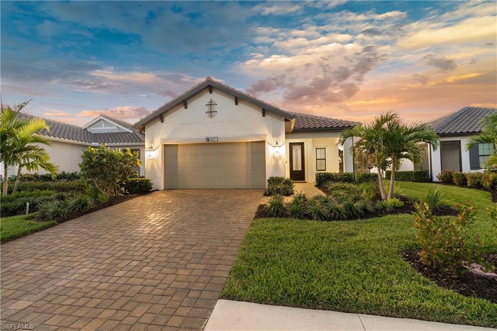 4621 Centaurus Circle Naples, FL 34120 - Photo 2 of 47 Mediterranean / spanish-style home featuring stucco siding, decorative driveway, an attached garage, a tiled roof, and a front yard