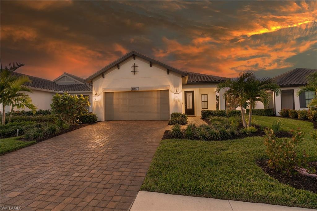 4621 Centaurus Circle Naples, FL 34120 - Photo 3 of 47 Mediterranean / spanish house with an attached garage, decorative driveway, stucco siding, a front yard, and a tile roof