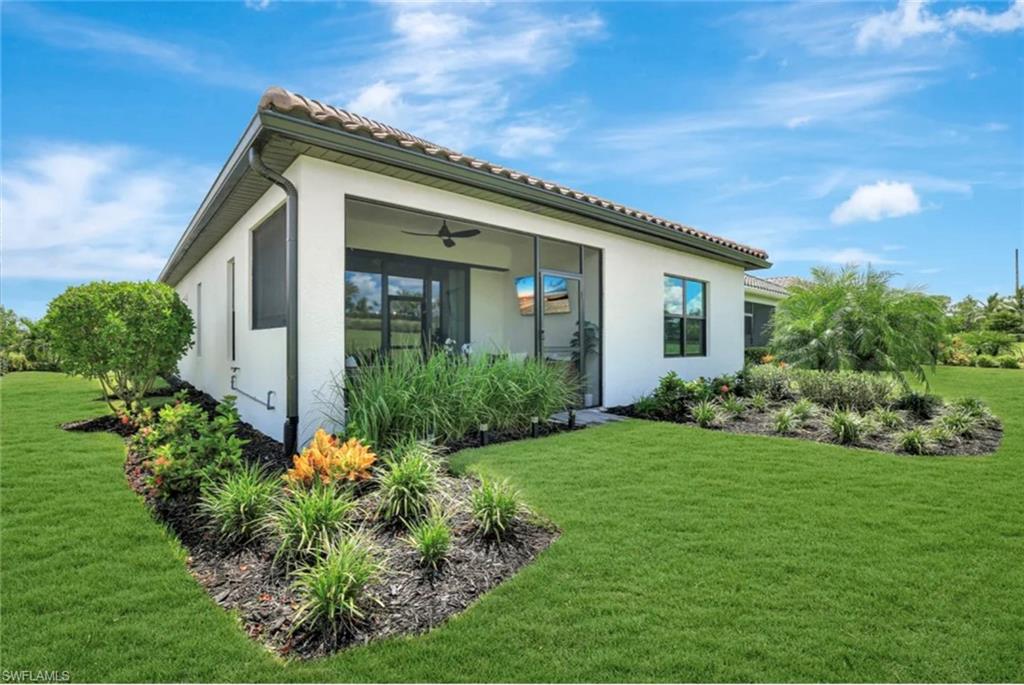 4621 Centaurus Circle Naples, FL 34120 - Photo 35 of 47 Rear view of property with a yard, stucco siding, and a ceiling fan