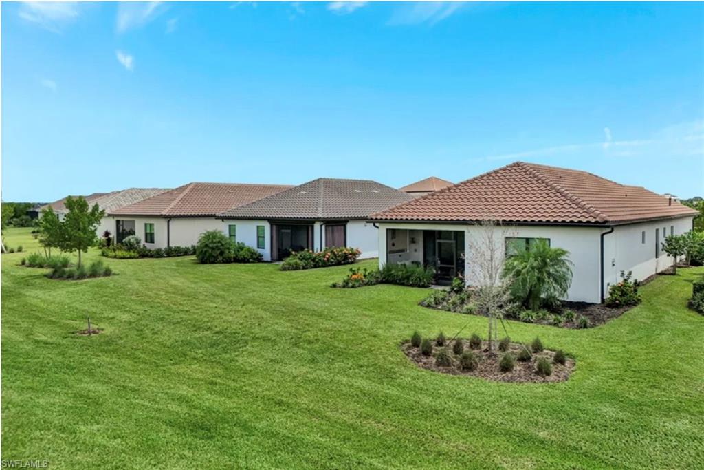 4621 Centaurus Circle Naples, FL 34120 - Photo 38 of 47 Rear view of property with stucco siding, a lawn, and a tiled roof