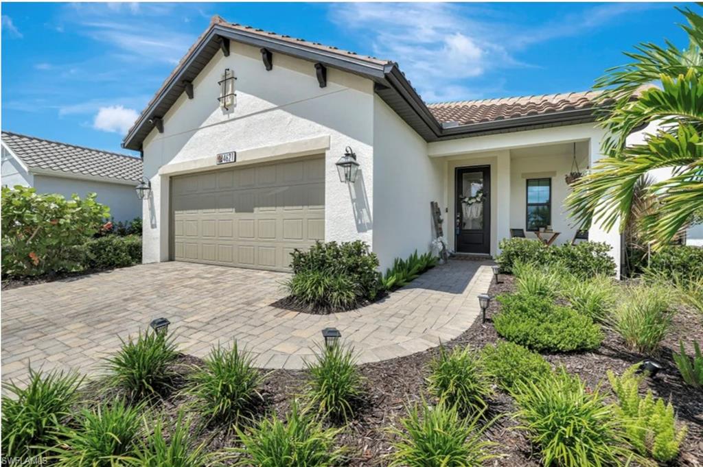 4621 Centaurus Circle Naples, FL 34120 - Photo 42 of 47 Mediterranean / spanish-style house featuring a garage, a tiled roof, stucco siding, and decorative driveway