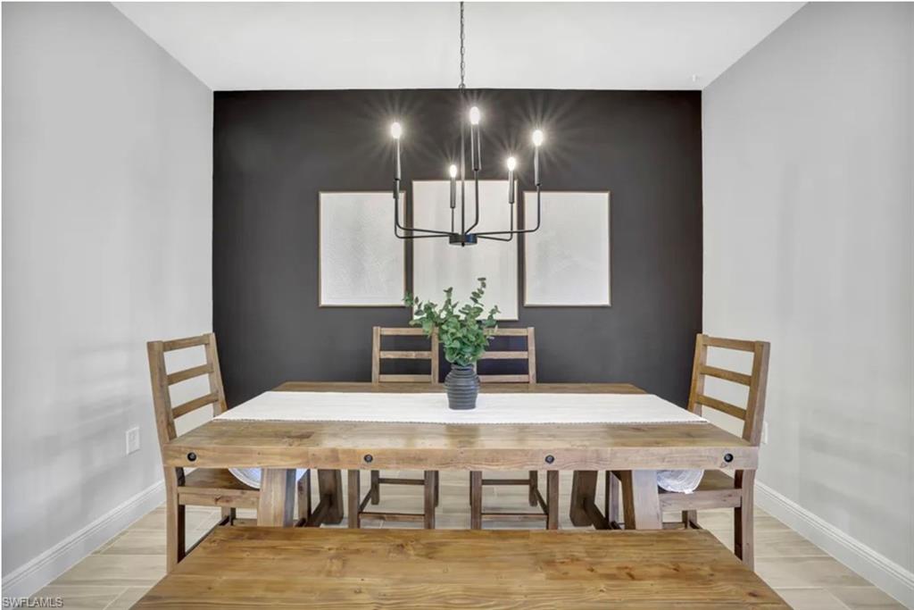 4621 Centaurus Circle Naples, FL 34120 - Photo 9 of 47 Dining room with an accent wall, a chandelier, and light wood-style tile floor staged for photo