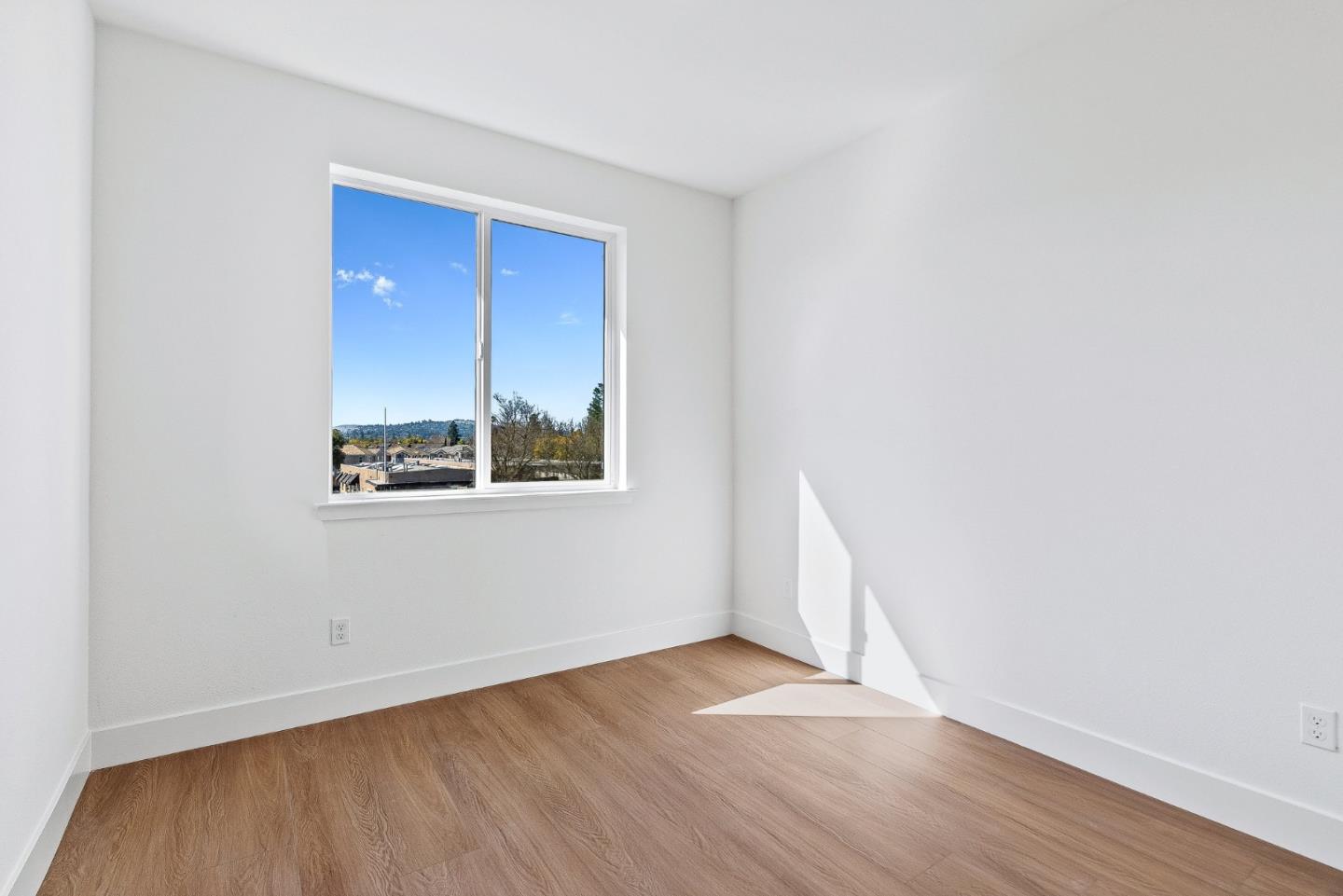 947 Woodside Road Redwood City, CA 94061 - Photo 19 of 51 an empty room with wooden floor and windows