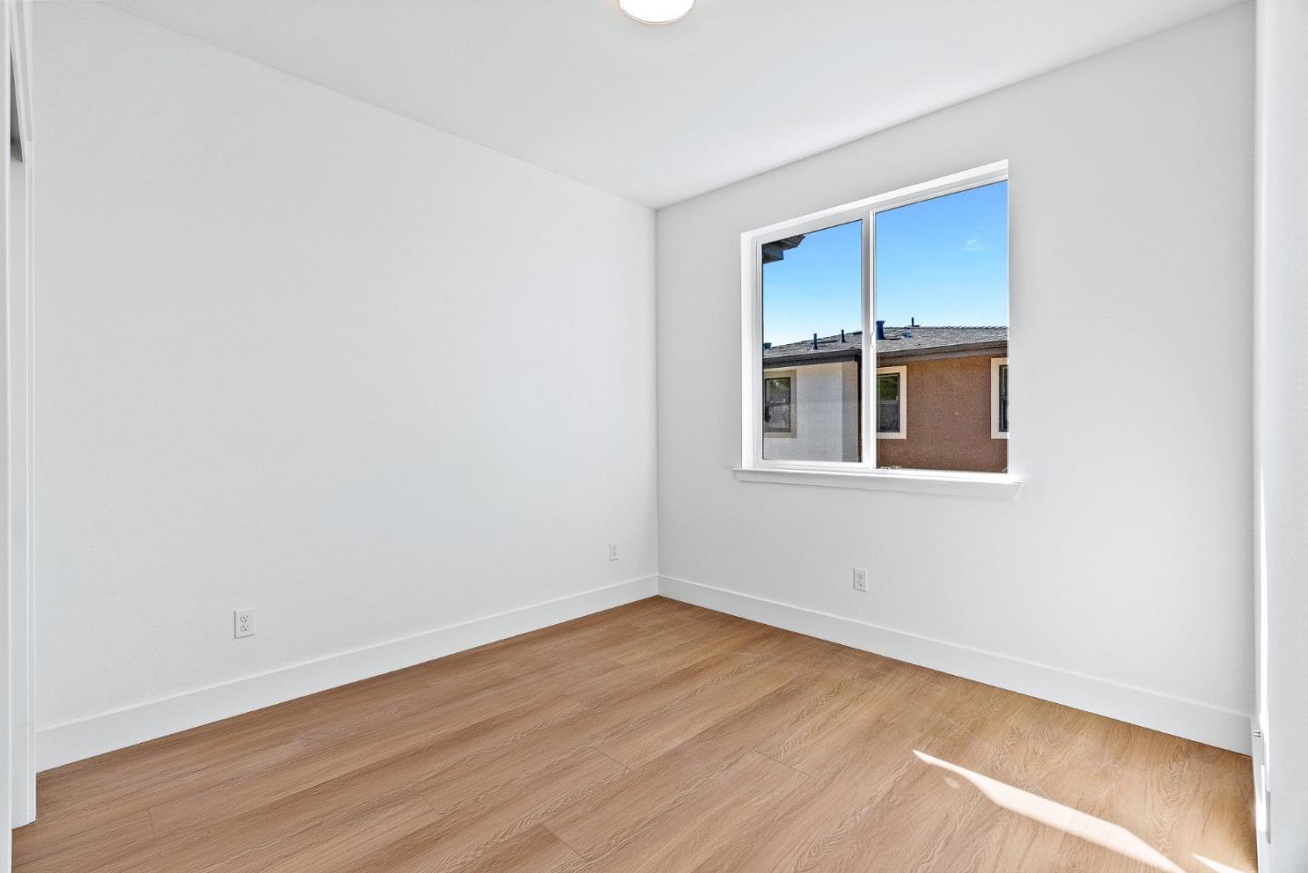 947 Woodside Road Redwood City, CA 94061 - Photo 21 of 51 a view of an empty room with wooden floor and a window