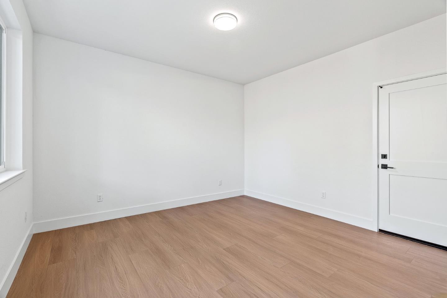 947 Woodside Road Redwood City, CA 94061 - Photo 4 of 51 an empty room with wooden floor and windows