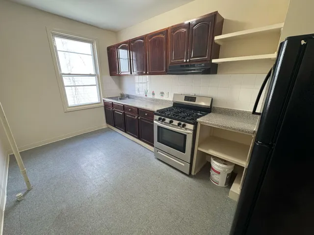 a kitchen with wooden cabinets and a stove top oven