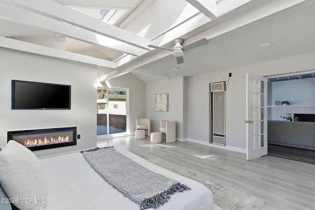 a spacious bedroom with a bed and a flat screen tv