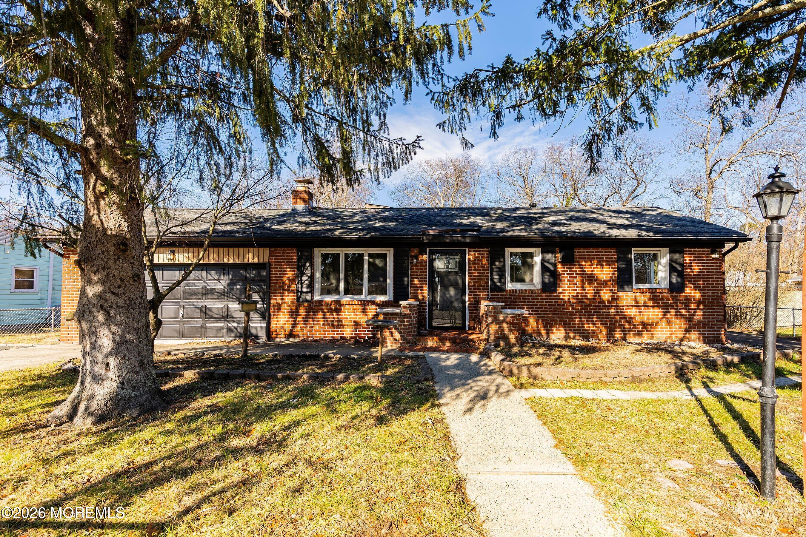 215 Sunset Lane Howell, NJ 07731 - Photo 2 of 27 a view of a patio with table and chairs under an umbrella with large trees