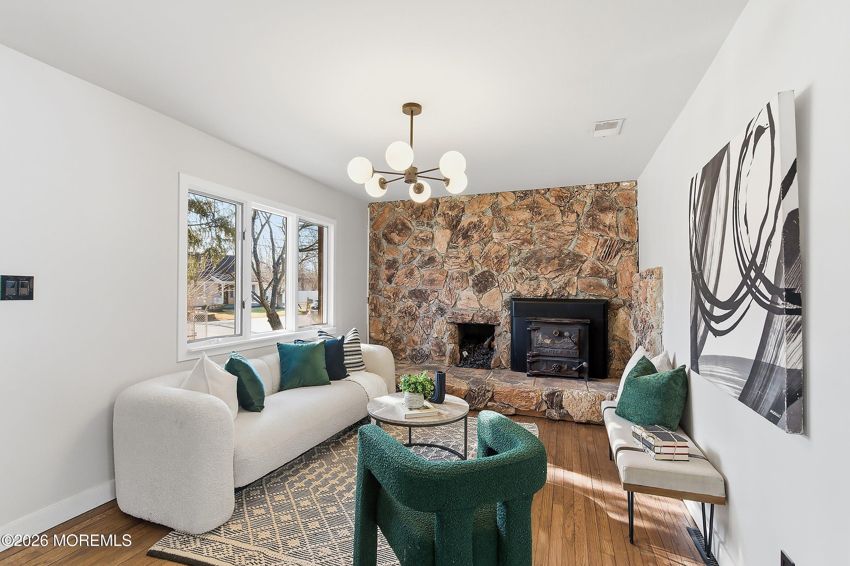 215 Sunset Lane Howell, NJ 07731 - Photo 5 of 27 a living room with furniture a fireplace and a chandelier