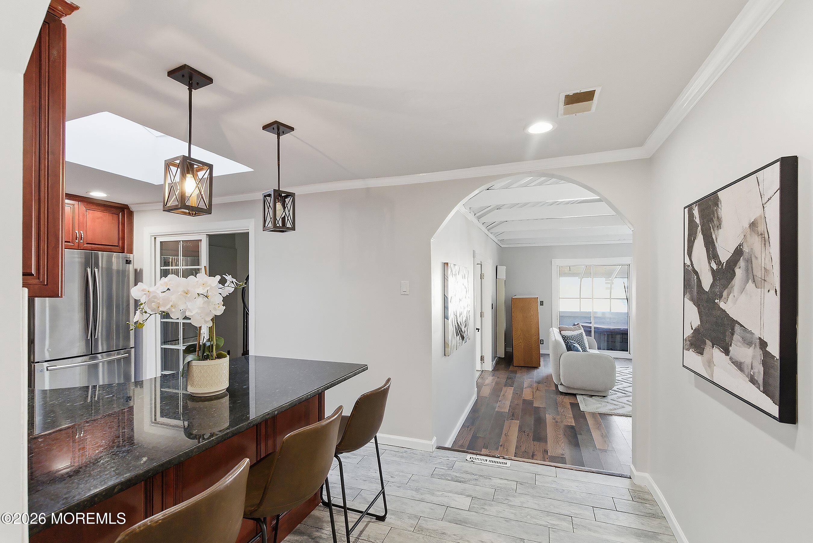 215 Sunset Lane Howell, NJ 07731 - Photo 7 of 27 a view of a dining room and livingroom with furniture wooden floor a chandelier