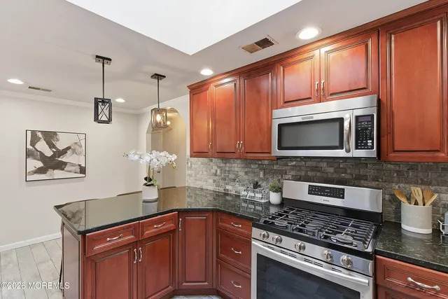 a kitchen with stainless steel appliances granite countertop a sink stove and microwave