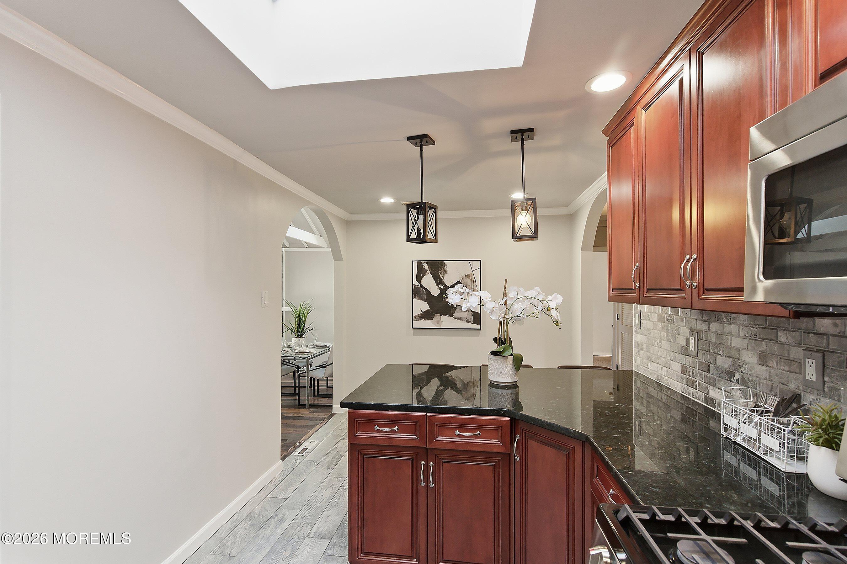 215 Sunset Lane Howell, NJ 07731 - Photo 10 of 27 a kitchen with stainless steel appliances granite countertop a sink stove and cabinets