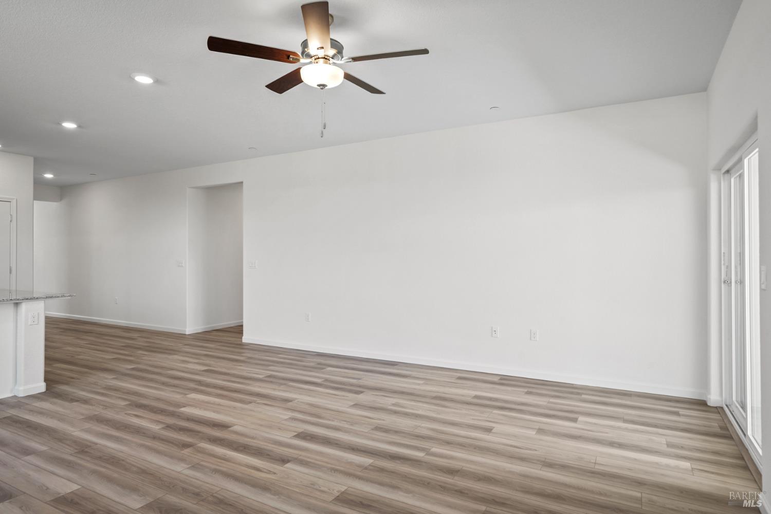 2240 Front Porch Lane Rio Vista, CA 94571 - Photo 10 of 16 a view of an empty room with wooden floor and a ceiling fan