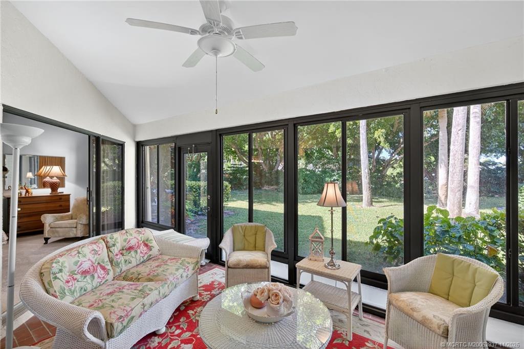 6001 Southeast Martinique Drive, Unit 104 Stuart, FL 34997 - Photo 15 of 36 a living room with furniture large windows and a chandelier