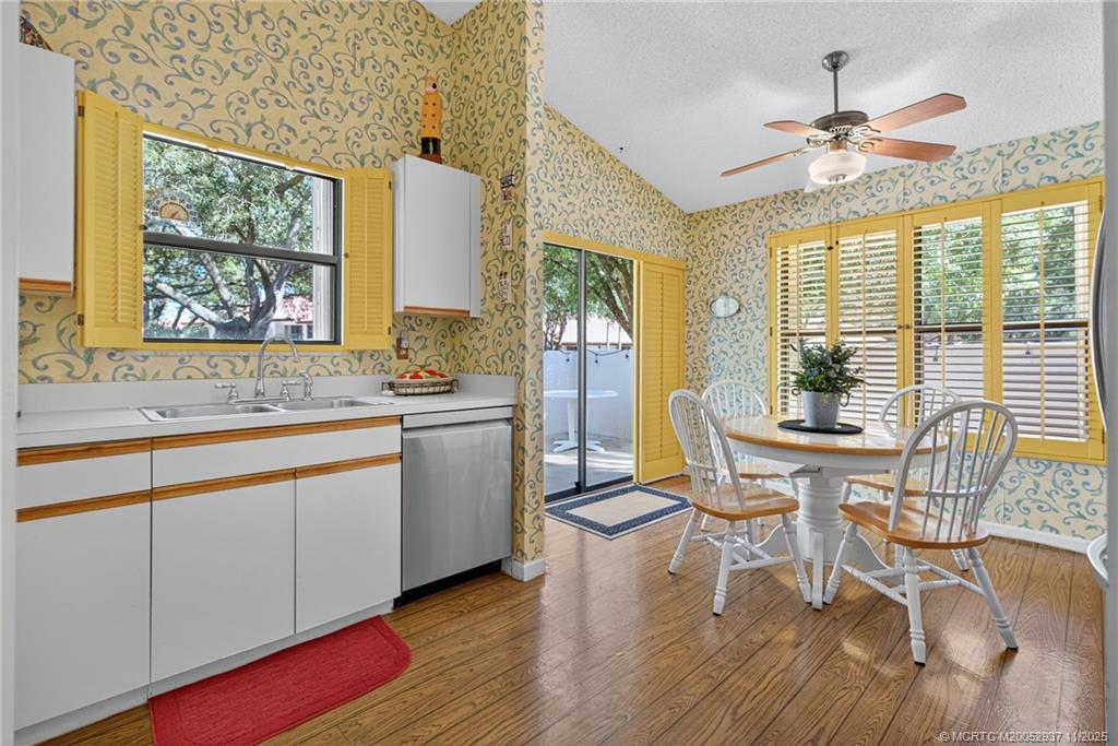 6001 Southeast Martinique Drive, Unit 104 Stuart, FL 34997 - Photo 16 of 36 a kitchen with a table chairs sink and cabinets