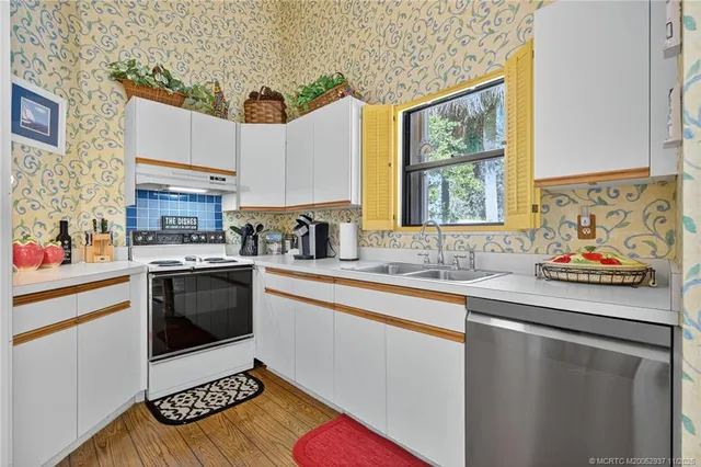 a kitchen with stainless steel appliances granite countertop a sink stove and cabinets