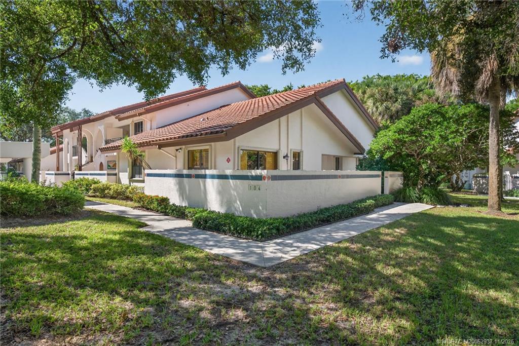 6001 Southeast Martinique Drive, Unit 104 Stuart, FL 34997 - Photo 2 of 36 a view of a house with a yard and sitting area