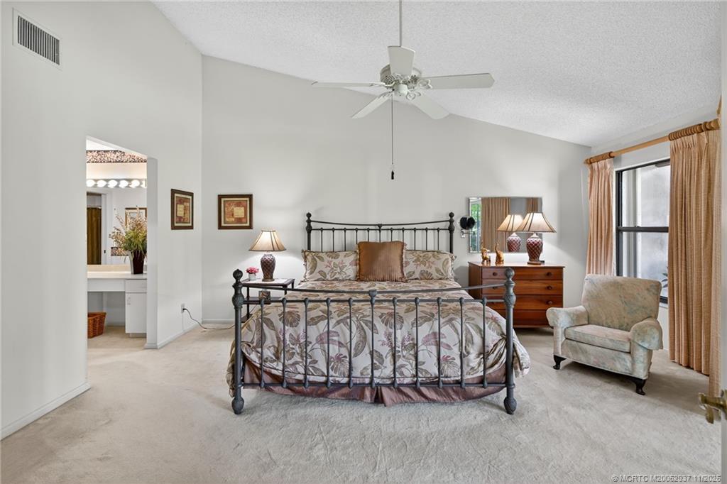 6001 Southeast Martinique Drive, Unit 104 Stuart, FL 34997 - Photo 21 of 36 a bedroom with a bed a couch and dresser