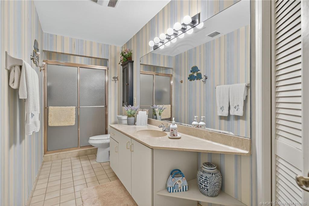6001 Southeast Martinique Drive, Unit 104 Stuart, FL 34997 - Photo 29 of 36 a bathroom with a sink a toilet and shower