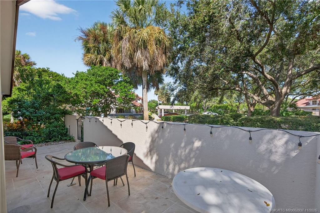 6001 Southeast Martinique Drive, Unit 104 Stuart, FL 34997 - Photo 5 of 36 a backyard of a house with table and chairs
