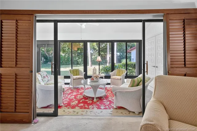 a living room with furniture and floor to ceiling windows