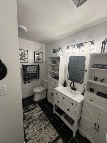 a bathroom with a sink mirror and toilet