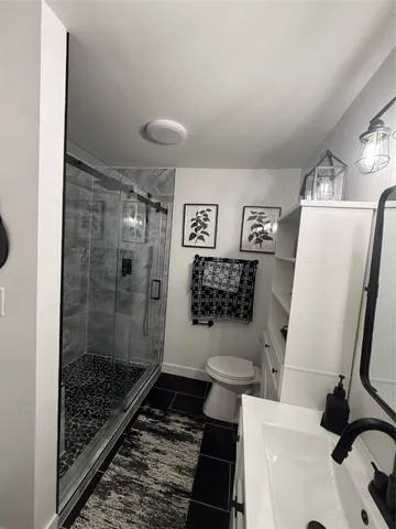 a bathroom with a toilet and a shower