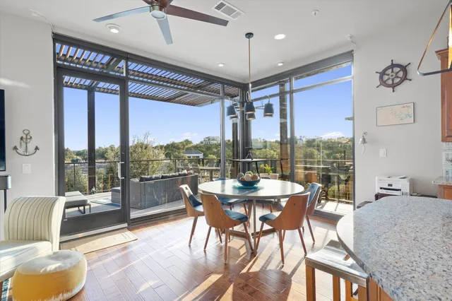 a view of a dining room with furniture large windows and wooden floor