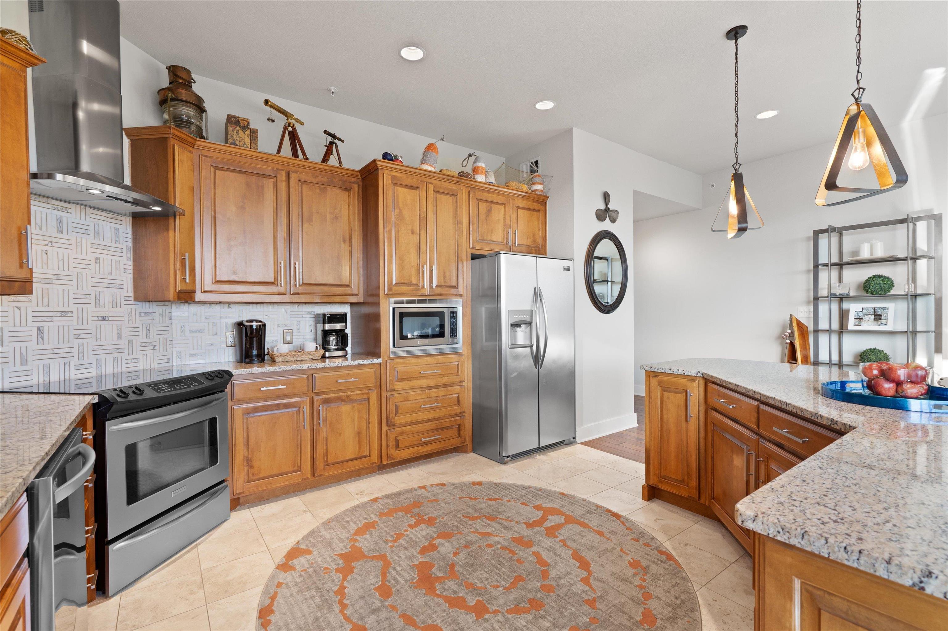 1101 Ivean Pearson Road Lago Vista, TX 78645 - Photo 10 of 30 a kitchen with stainless steel appliances granite countertop a refrigerator a sink dishwasher and wooden cabinets with wooden floor