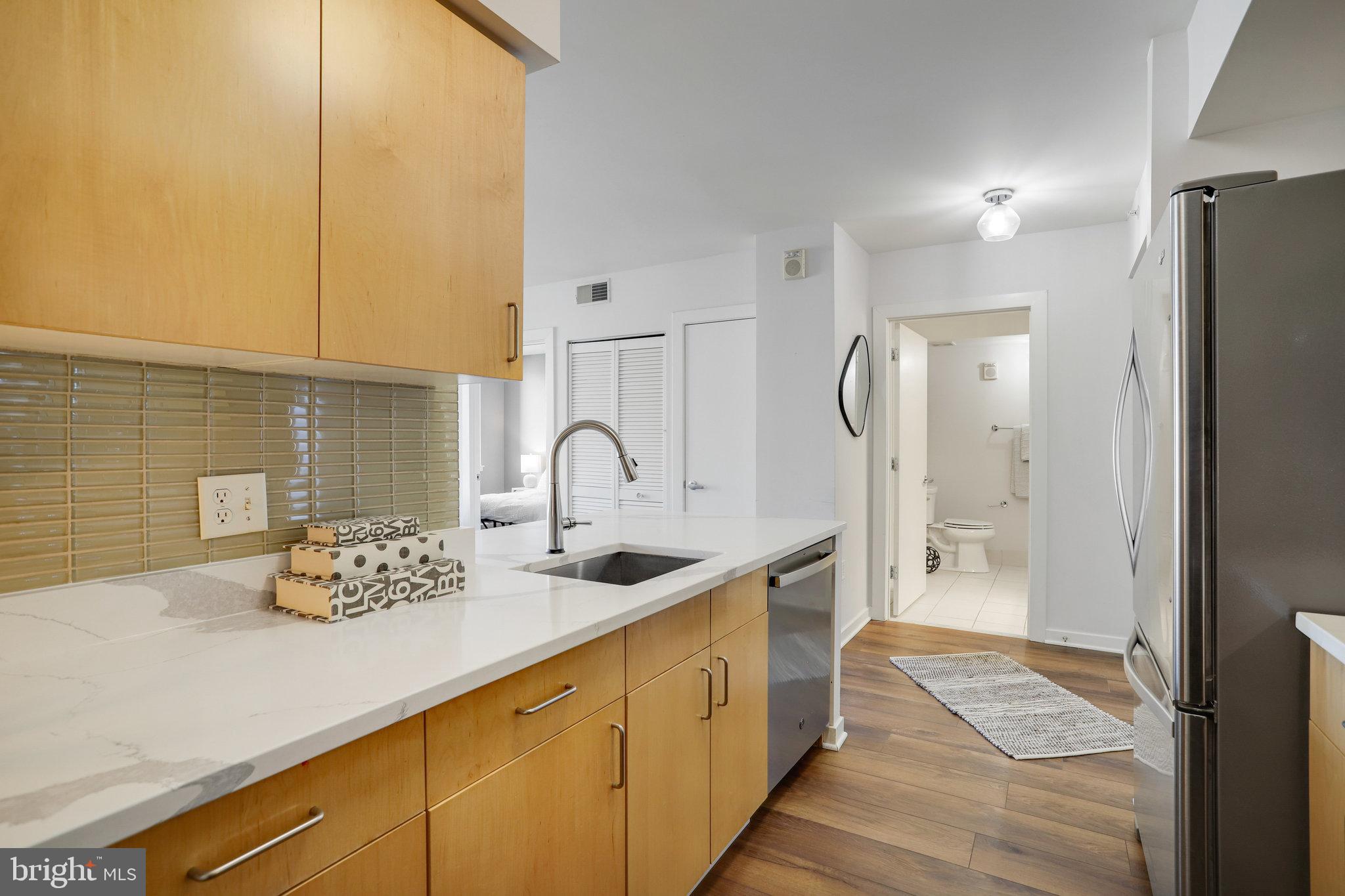 1000 New Jersey Avenue Southeast, Unit 914 Washington, DC 20003 - Photo 12 of 48 a kitchen with stainless steel appliances granite countertop a sink and a refrigerator