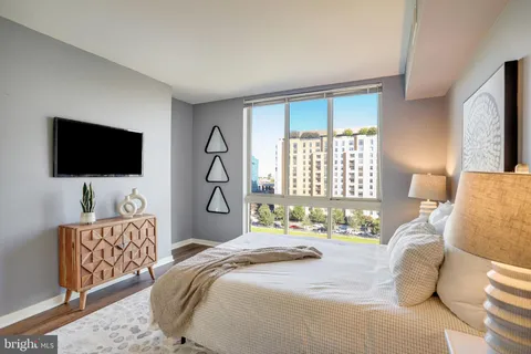 a bedroom with bed tv and window