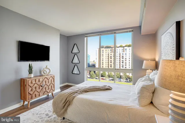 a bedroom with bed tv and window