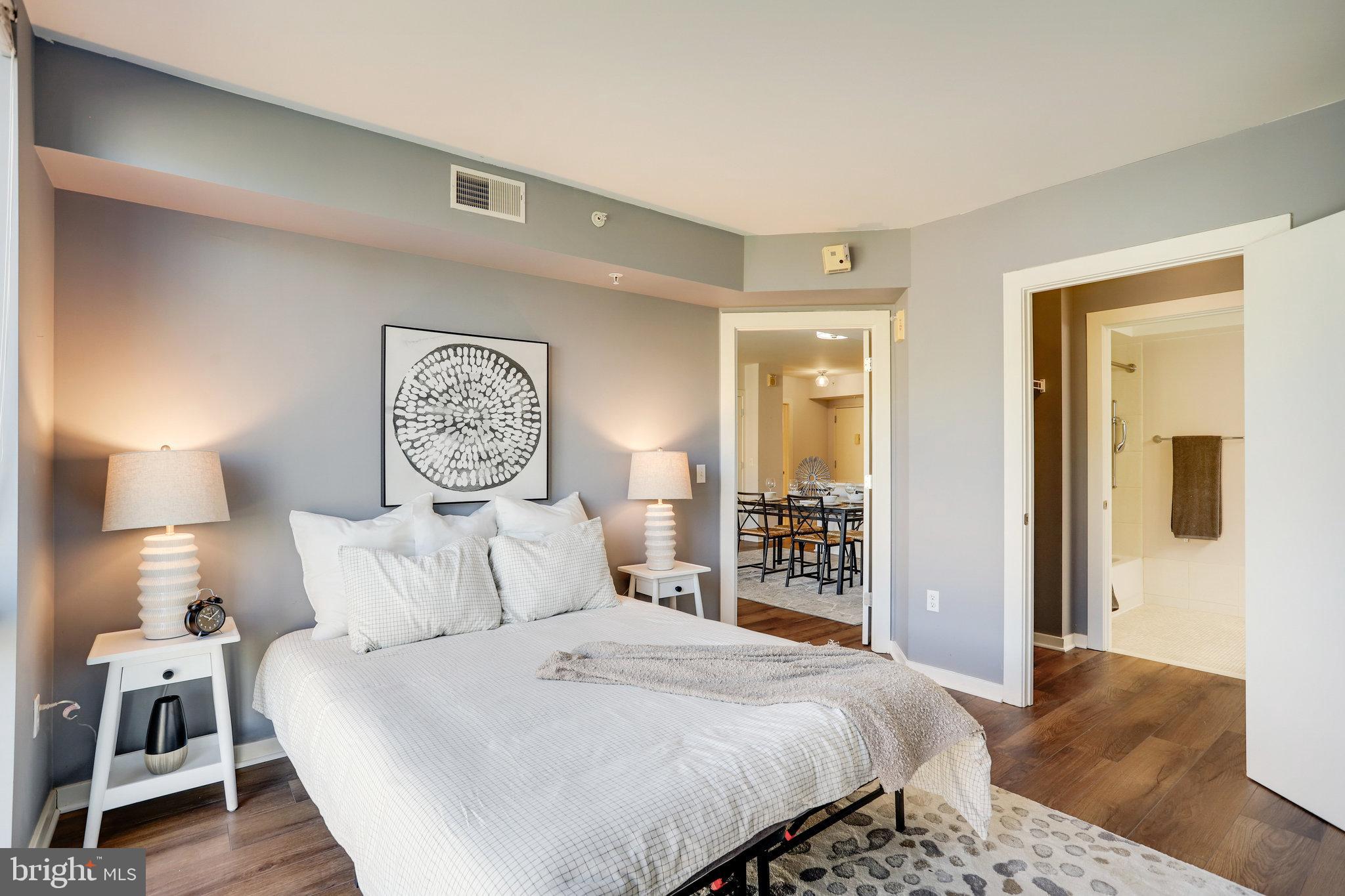 1000 New Jersey Avenue Southeast, Unit 914 Washington, DC 20003 - Photo 16 of 48 a bedroom with a large bed and a lamp