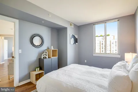 a bedroom with a bed a mirror and a window